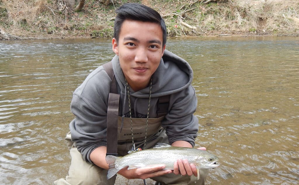 student shows off a fish he caught