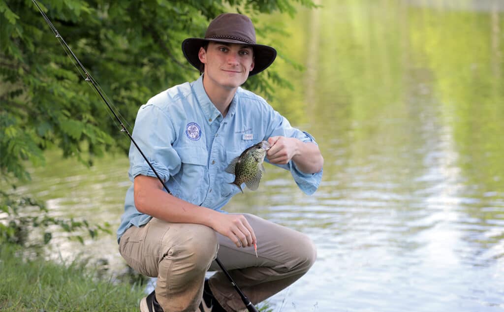 student shows off the fish he caught