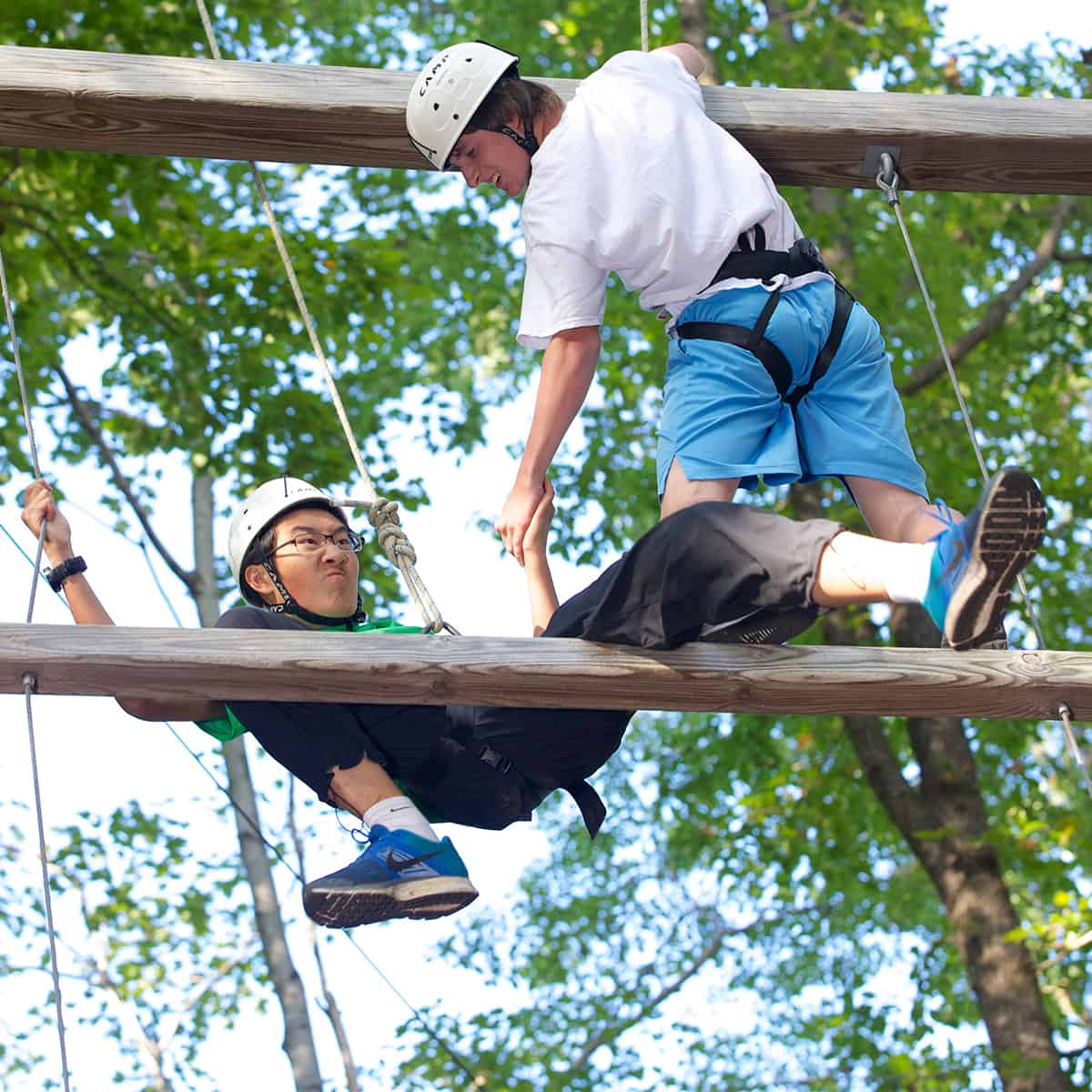 students climb the outdoor challenge course