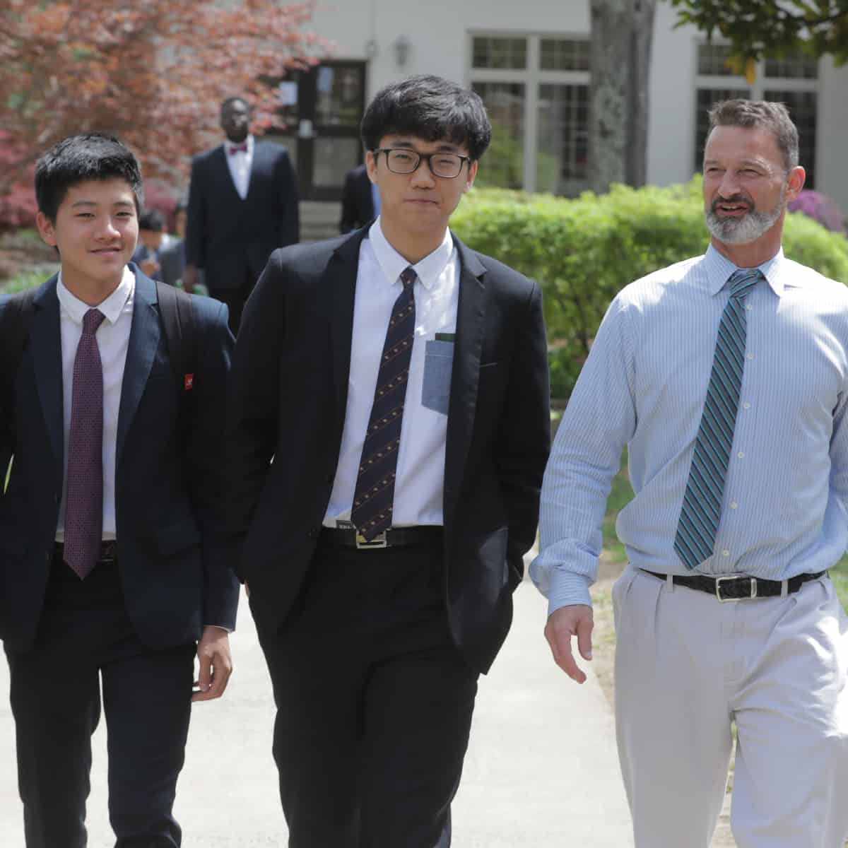 Students and teacher walking on the sidewalk