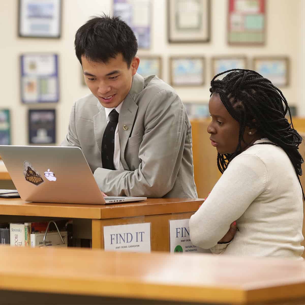 Student working with a teacher in the library